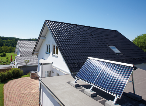 Ein Haus mit Solarkollektor auf dem Flachdach der Garage.