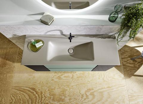 Eine Vogelperspektive auf ein modernes Badezimmer mit einem rechteckigen Waschbecken in Beige und einer minimalistischen Waschtischoberfläche.