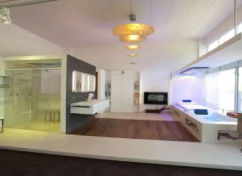 Ein moderner Showroom der Ausstellung Bad Staib in Pforzheim präsentiert ein luxuriöses Badezimmer mit einer begehbaren Glasdusche und einer eleganten Badewanne mit LED-Beleuchtung.