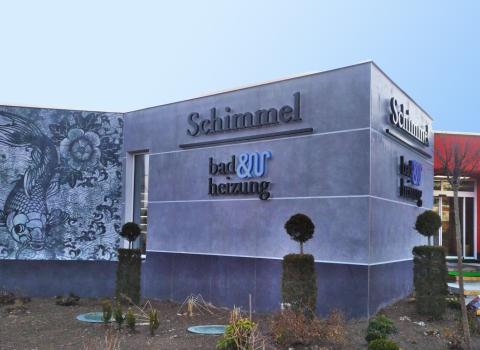 Die Außenansicht der Wohnbad Schimmel Ausstellung in Hof zeigt eine moderne, graue Fassade mit einem kunstvollen Wandmotiv eines Koi-Fisches.