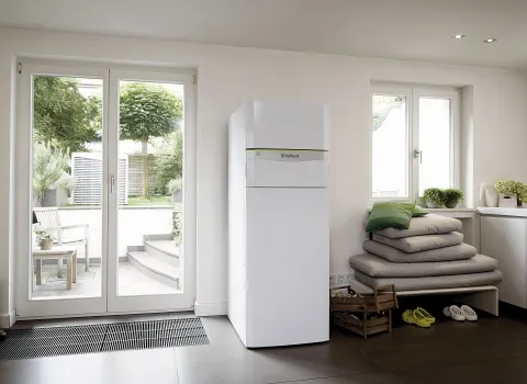 Eine Wärmepumpe von Vaillant steht in einem eleganten Innenraum mit Blick auf einen grünen Garten.