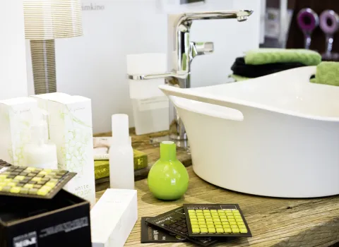 Badausstellung mit verschiedensten Marterialien, die auf einen Waschsitshc platziert sind.