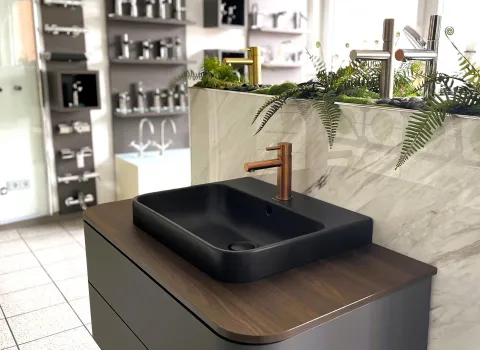 Aufsatzwaschtisch mit bronzfarbener Armatur in der Badausstellung  von müller+sohn in Frechen.