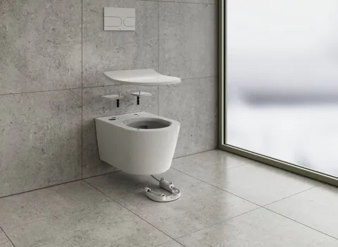 In einem stilvollen Badambiente ist ein wandmontiertes WC mit der TOTO FlexCover zu sehen, die ergonomisch über der Schüssel schwebt.