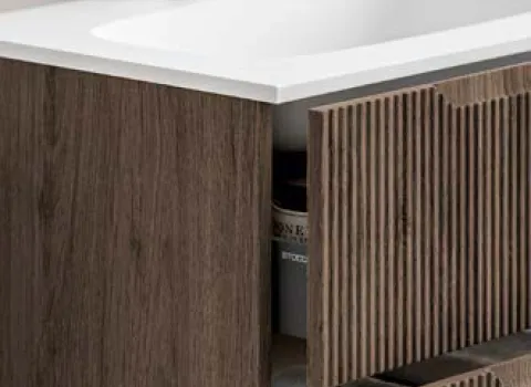 Detailansicht eines Waschtischs mit geriffelter Eichenfront und weißer Waschtischplatte.