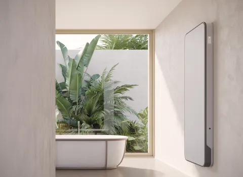 Vertikaler weißer Designheizkörper Relax Hybrid im modernen Badezimmer.
