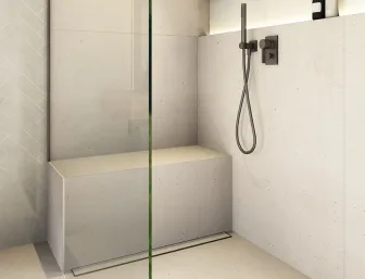 Moderne Walk-In-Dusche mit Glasabtrennung, integrierter Sitzbank und Regenduschkopf. Eine beleuchtete Nische bietet Platz für Duschgel und Shampoo.