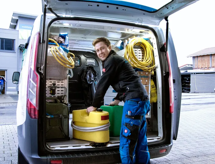 Kundendiensttechniker (SHK) vor Service-Fahrzeug.